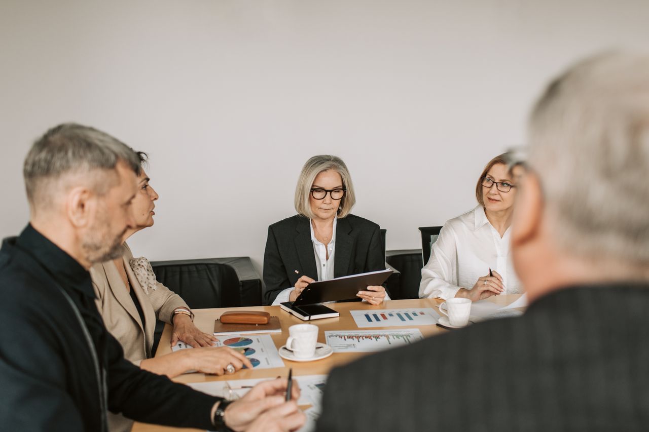 Experienced professionals reviewing documents around a meeting table