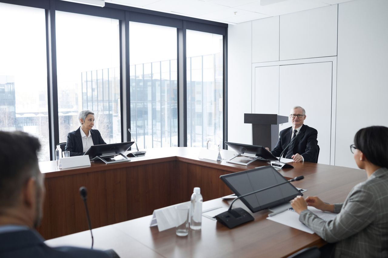Board members discussing company matters around a formal conference table
