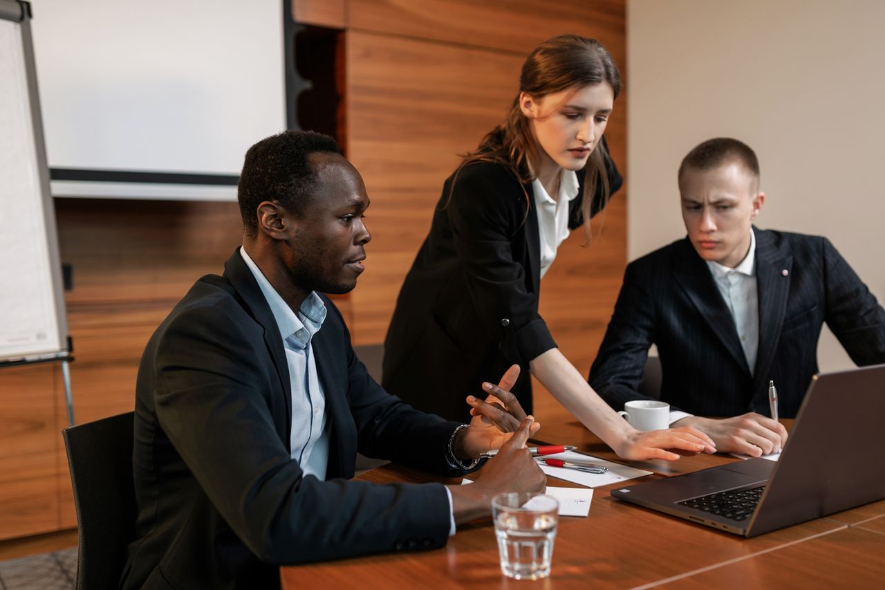 Professionals discussing business around a wooden meeting table
