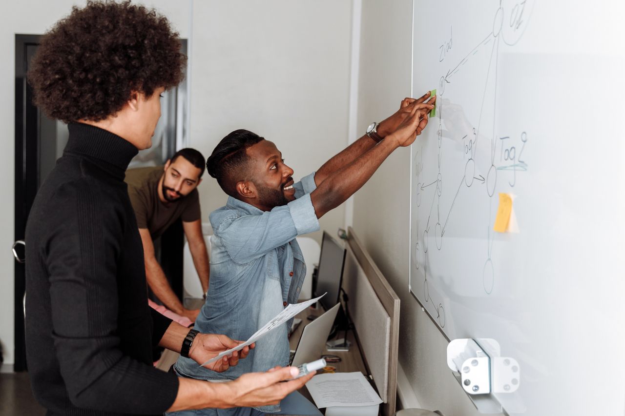 Participants discussing and developing ideas together at a whiteboard
